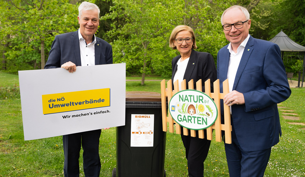 drei Personen stehen im freien vor einer Biomüll-Tonne und halten Tafeln mit den Logos der NÖ Umweltverbände und von Natur im Garten